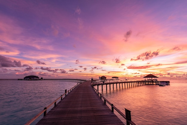 Incredibile tramonto alle maldive. vista sul mare di ville resort di lusso, fantastiche nuvole di cielo colorate, vacanze