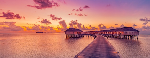 Amazing sunset panorama at Maldives. Luxury resort villas seascape with colorful sky colorful clouds