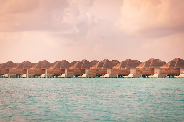 Amazing sunset panorama at Maldives Luxury resort villas seascape with soft colorful sky Tropics