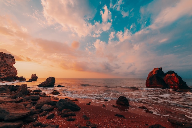 Photo amazing sunset at sea, beauty of nature. scenic view of the sea, rocky coastline and sandy beach, golden sky and sun, outdoor travel background. general's beaches. crimea.