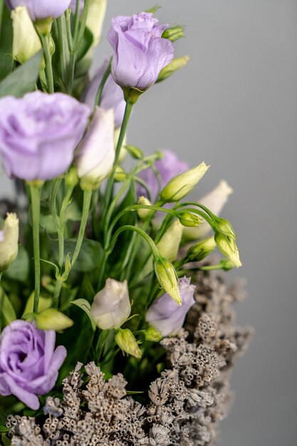 Amazing tender bouquet with pink ranunculus violet flowers and tiny white roses in cardboard box with pink ribbon Beautiful bunch of spring flowers Easter gift Seasonal spring flowers