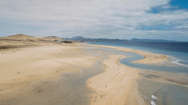 素晴らしい熱帯のビーチと青い透明な海の海の水海岸線の空中写真と背景に地平線と空と山のある素晴らしい海の風景夏の旅行