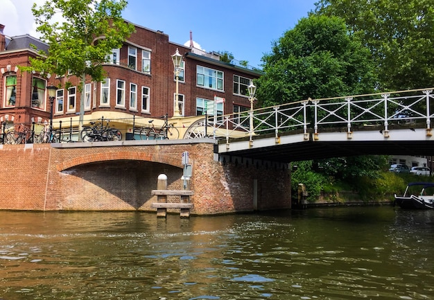 오데그라흐트(Oudegracht) 오래된 운하와 아름다운 건물의 다리 중 하나에 있는 관광 보트의 놀라운 전망