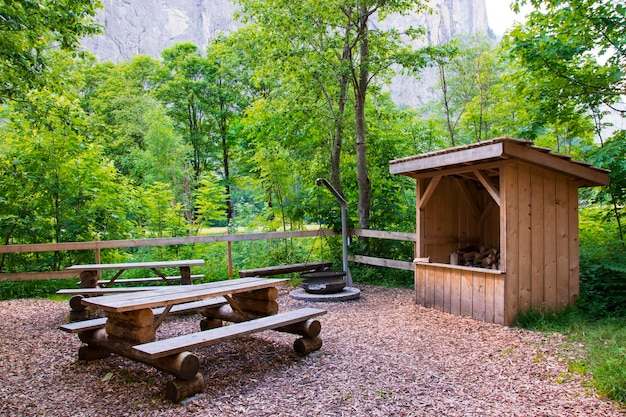 Amazing view of a wooden bench and a small hut in the forest, resting area for hikers in Interlaken.