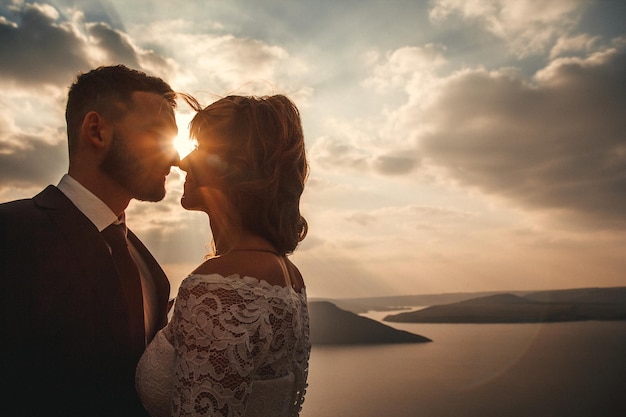 Amazing wedding couple bride and groom holding hands on a mountains and rivers background