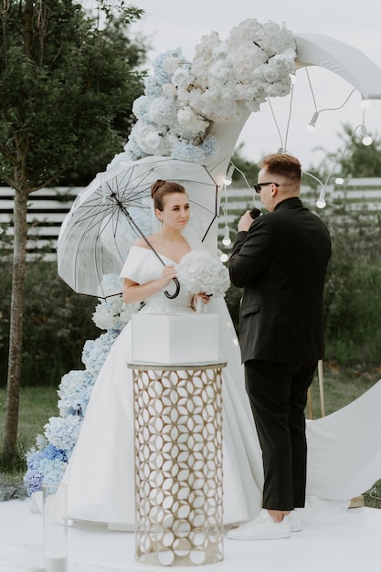 Photo amazing wedding couple near wedding arch