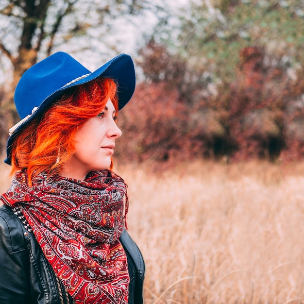 Amazing woman is walking in the park in cloudy weather in the autumn.