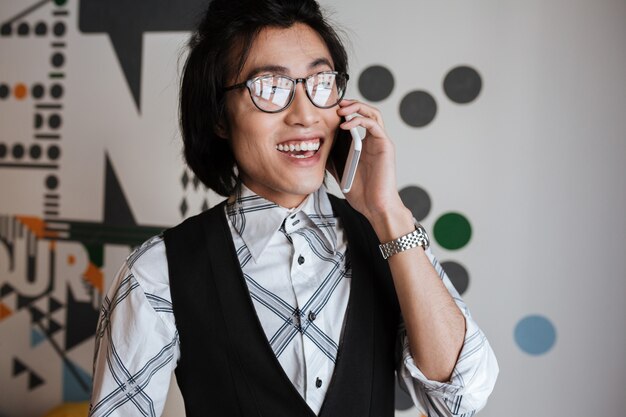 휴대 전화로 이야기하는 놀라운 젊은 아시아 남자