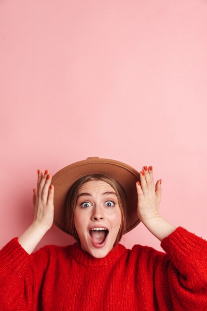 amazing young shocked emotional woman posing isolated over pink wall.