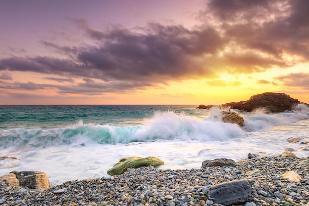 Amazinl scenery of wave splashing at the sunrise stormy sea at the morning Sundown sky with clouds