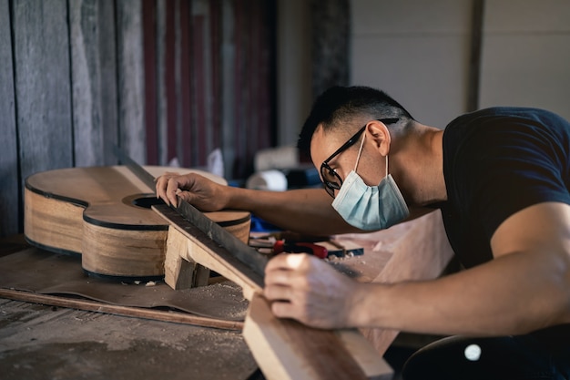 Ambachtelijke man gitaar maken op houten tafel, capenter werkconcept