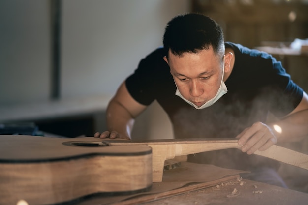 Ambachtelijke man gitaar maken op houten tafel, capenter werkconcept