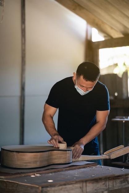 Ambachtelijke man gitaar maken op houten tafel, capenter werkconcept