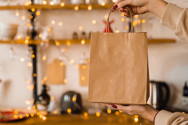 Ambachtelijke tas om te winkelen op oudejaarsavond. Zak op de achtergrond van Kerstmislichten. Nieuwjaarsverkoop