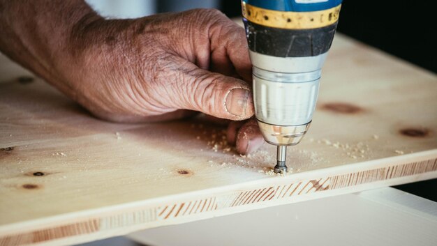 Ambachtsman boort in hout met boormachine