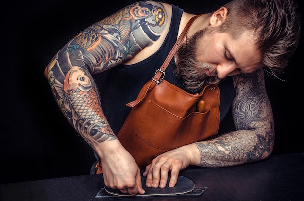 Ambachtsman die met leer werkte, concentreerde zich op zijn werk in de leerstudio.