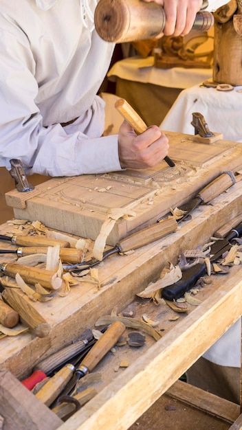 ambachtsman houtsnijwerk in een middeleeuwse kermis, timmerwerk tools