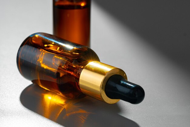 Amber glass bottles for cosmetics natural medicine or essential oils on gray background