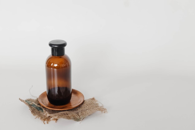 Косметическая бутылка из янтарного стекла на упаковке в деревенском стиле, макет для ухода за телом и кожей