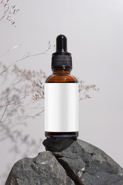 Amber glass dropper bottle with a pipette on stones grey background Natural cosmetics concept natural essential oil