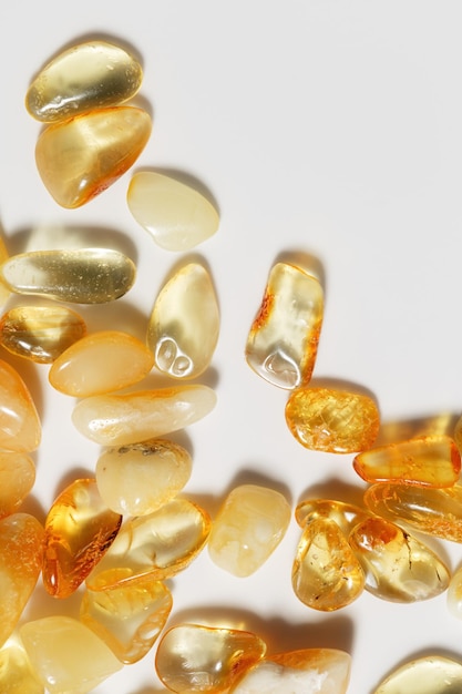 Foto amber stenen op een lichte achtergrond doorzichtige steen gele beige gradiënt kleur natuurlijke edelsteen minerale genezende kristal top view amber textuur fon natuur edelstenen stukken oude hars