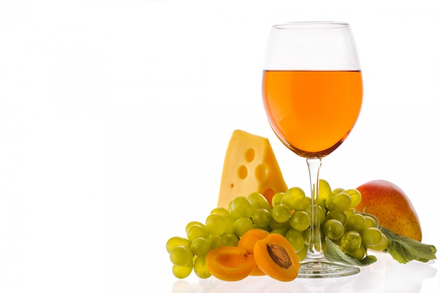 Amber wine. Wine in a glass near fruits, grapes and cheese. Traditional Georgian wine according to ancient technology. Isolated on white background. Copy space. Close up and horizontal orientation.