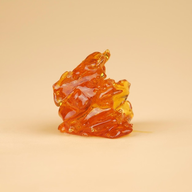 Amber yellow piece of cannabis wax with high thc close up