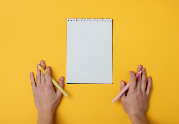 Photo ambidextr two female hand with pens and notebook