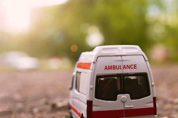 Ambulance car on the asphalt among the trees