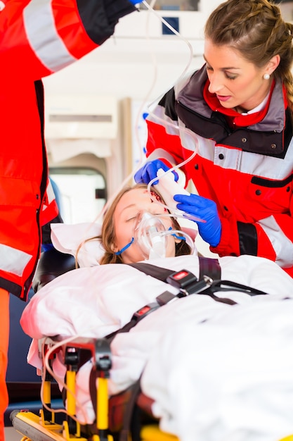 Photo ambulance helping injured woman on stretcher