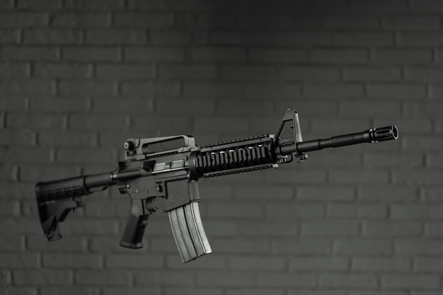 The American army rifle M4A1 against a brick wall