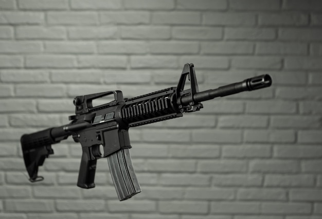 The American army rifle M4A1 against a brick wall