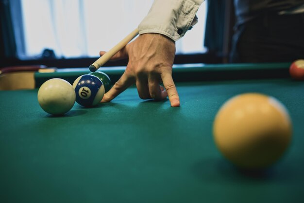 American billiard Man playing billiard snooker Player preparing to shoot hitting the cue ball