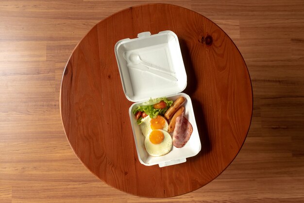 American breakfast meal style in a box set. small meal of hams\
and fried eggs