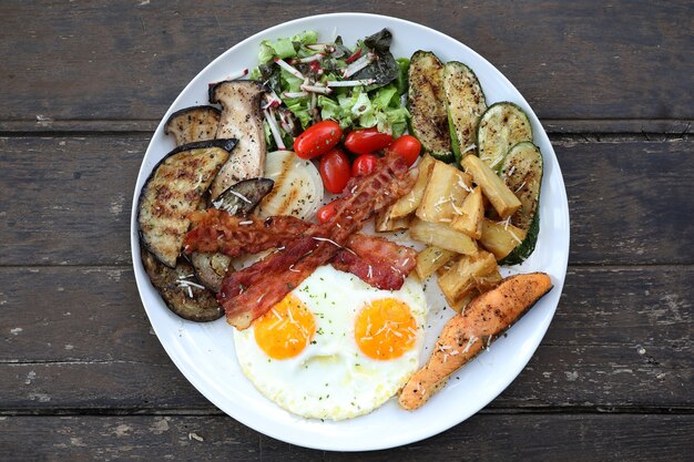 American breakfast with egg bacon sausage and salad