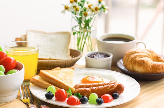 American breakfast with fried egg toast sausage fruits vegetable coffee croissant 