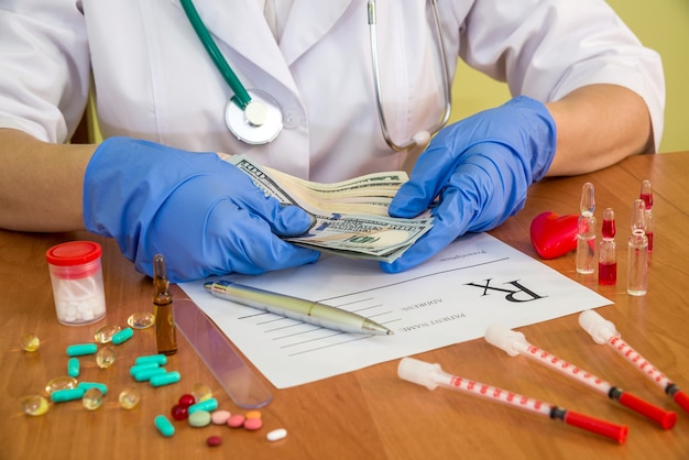 American dollar banknotes in doctor's hands .