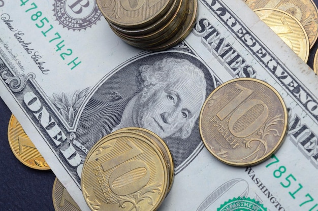 Американский доллар поверх которого лежат российские монеты номиналом 10 рублей Перевод надписей на монетах quot10рублейquot крупным планом