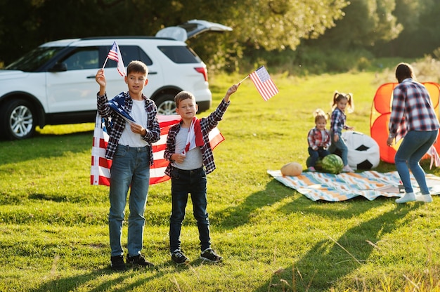 アメリカの家族。母と4人の子供。アメリカの旗付き。アメリカを祝う。