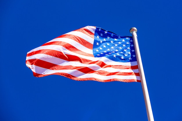 Американский флаг против голубого неба.