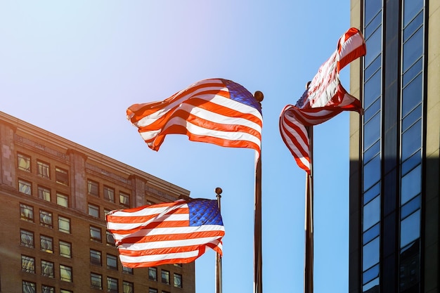 American flag against bright blue sky american flag against the sky and skyscrapers flag of the usa