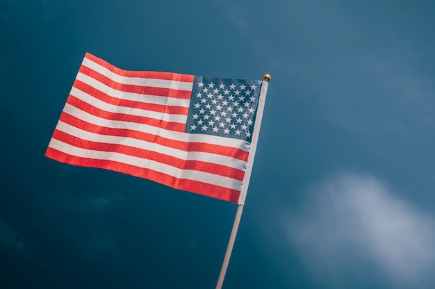 Американский флаг на фоне пасмурного неба.