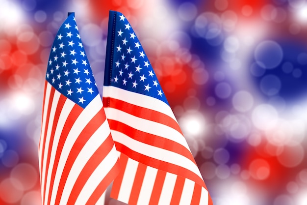 Американский флаг на фоне цветного боке бело-синего и красного цветов на День независимости США