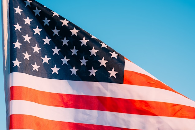 青い空にアメリカの国旗をクローズアップ。アメリカでの7月4日の独立記念日のシンボル