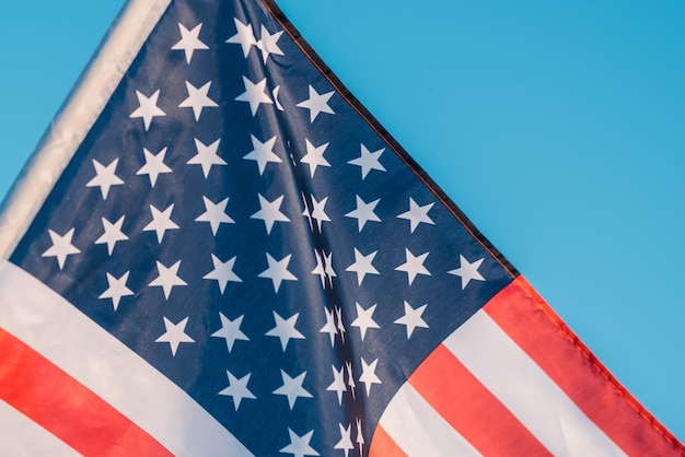 American flag in a blue sky, close up. Symbol of Independence Day fourth of July in USA