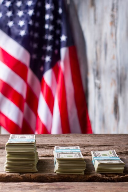 Photo american flag and dollar bundles. stacks of cash beside flag. yearly salary has grown. income of average citizen.