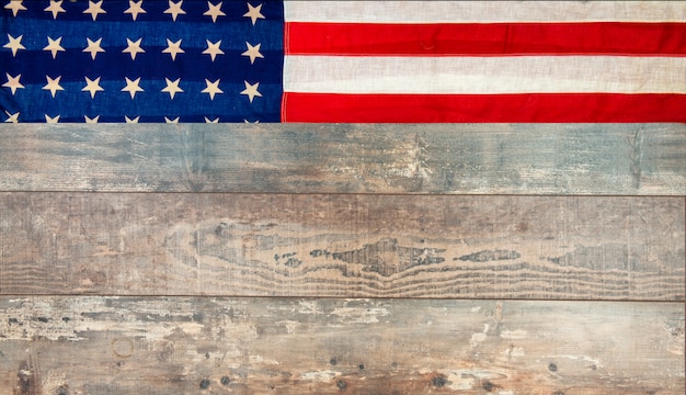 Photo american flag lying on an aged, weathered rustic wooden surface