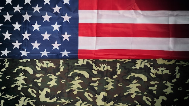 American flag and Military camouflage pattern. Top view angle. Soldier flag with national American flag on white background. Represent military concept by camouflage fabric and USA national flag.