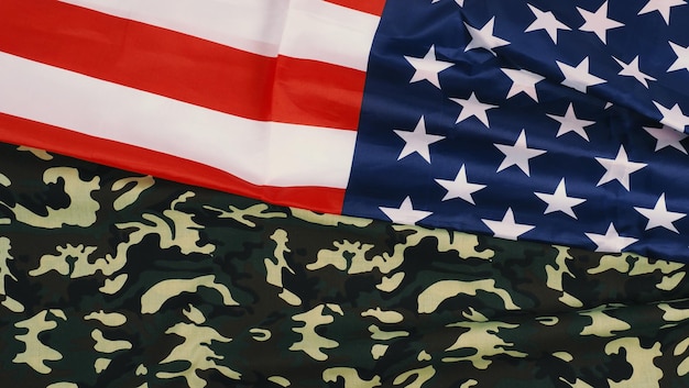 American flag and Military camouflage pattern. Top view angle. Soldier flag with national American flag on white background. Represent military concept by camouflage fabric and USA national flag.