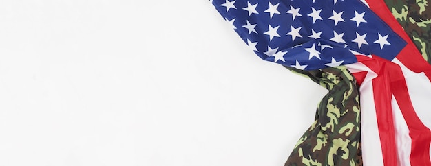 American flag and Military camouflage pattern. Top view angle. Soldier flag with national American flag on white background. Represent military concept by camouflage fabric and USA national flag.